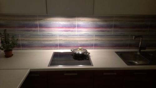 Дизайн кухни гостинной 40 кв м. Дизайн современной кухни-гостиной 40 кв м с фасадами из стекла и пеналами с техникой