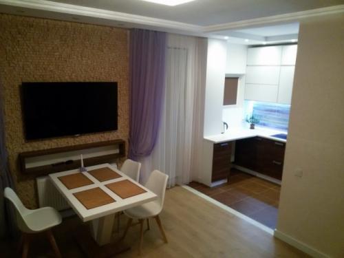 Дизайн кухни гостинной 40 кв м. Дизайн современной кухни-гостиной 40 кв м с фасадами из стекла и пеналами с техникой