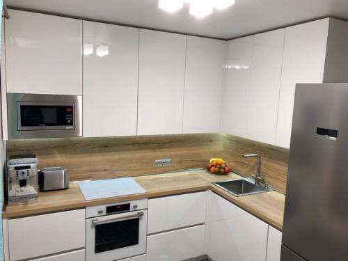 Просторная кухня белого цвета.