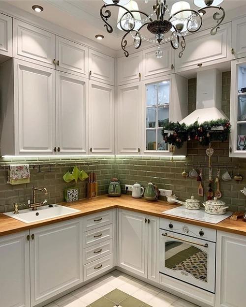 Красивое сочетание зелёного фартука и белой кухни.