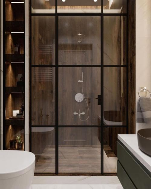 Дизайн санузла.  На стеклянной перегородке чёрные профили, а ещё плитка под дерево здорово тут смотрится.