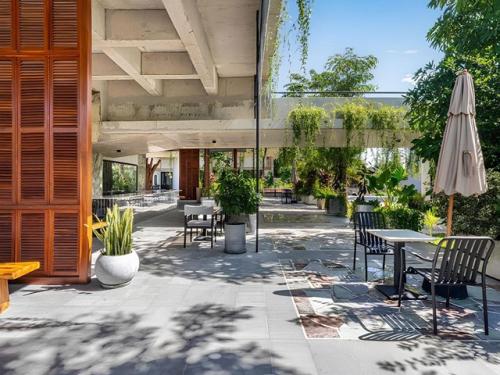 Архитекторы студии Khoan + Partners вдохнули жизнь в недостроенное бетонное здание в Камбодже, превратив его в стильное кафе с биофильным дизайном. 05